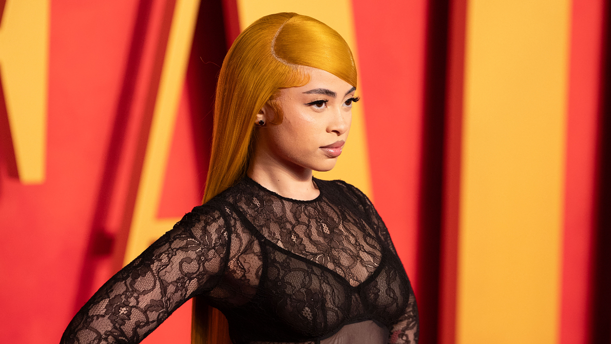 Person in a lace outfit and unique hairstyle posing