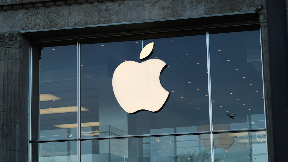 Apple logo on a store facade with interior lights visible