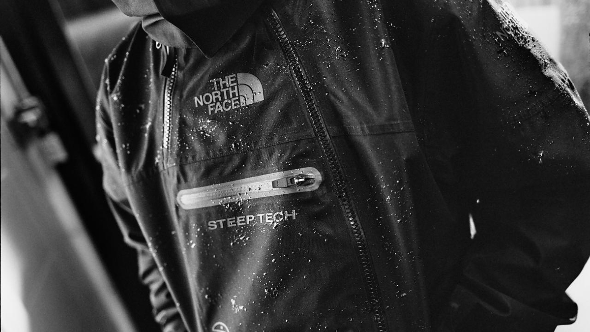Close-up of a wet jacket with 'The North Face' and 'Steep Tech' logos