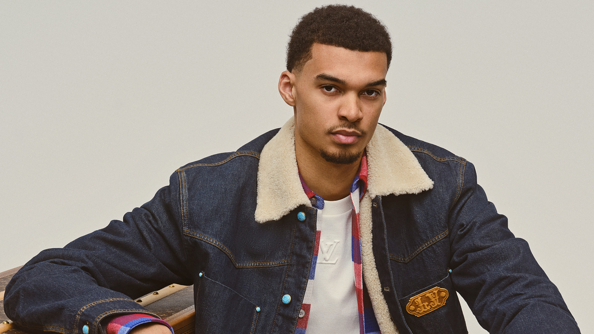 Young man models in a denim jacket with shearling collar and a graphic tee, exuding a casual style