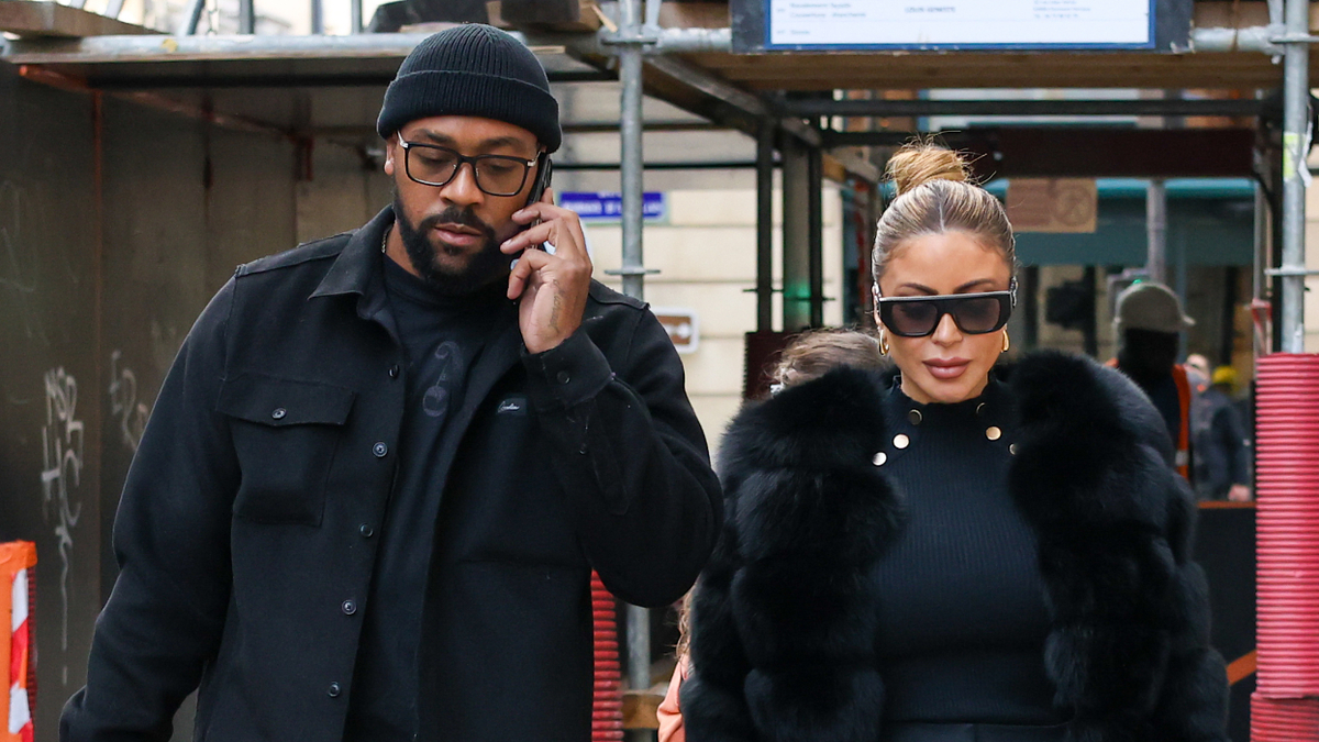Two individuals walking, one talking on a phone, both wearing stylish winter attire