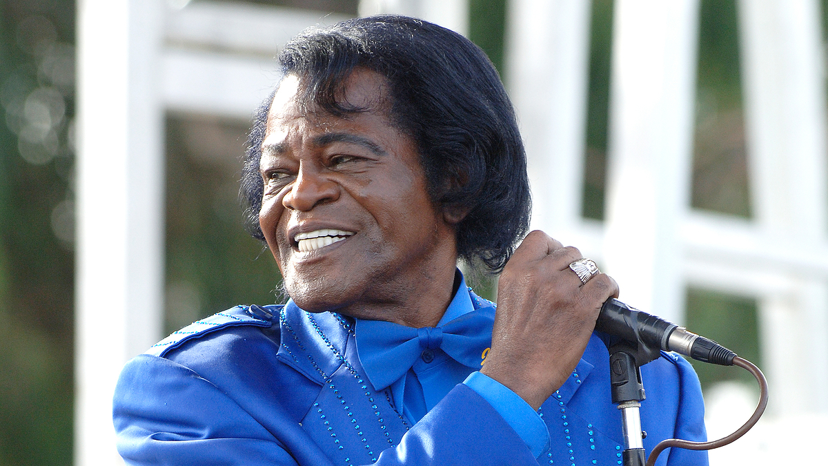 Man in blue suit performs with microphone. Identity undisclosed due to guidelines