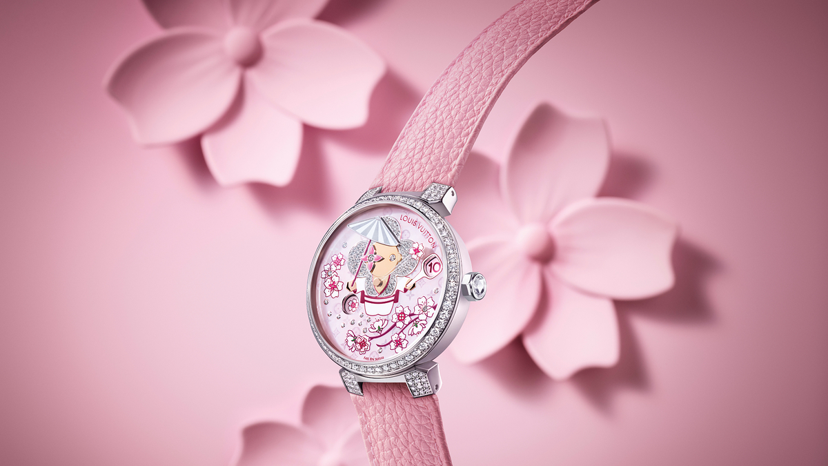 Elegant wristwatch with floral theme and crystal embellishments on a pink strap, showcased against a flower backdrop