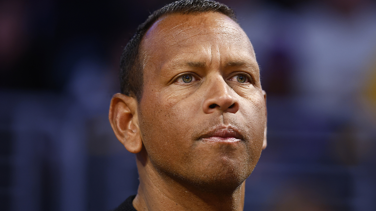 Man wearing a black top and a watch, looking to the side with a focused expression