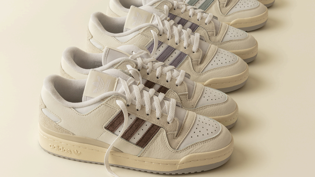 Five pairs of Adidas sneakers in a row with untied laces on the front pair