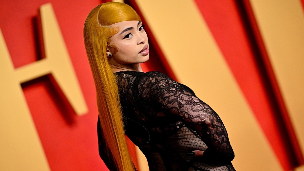Nicki Minaj poses in lace outfit against event backdrop