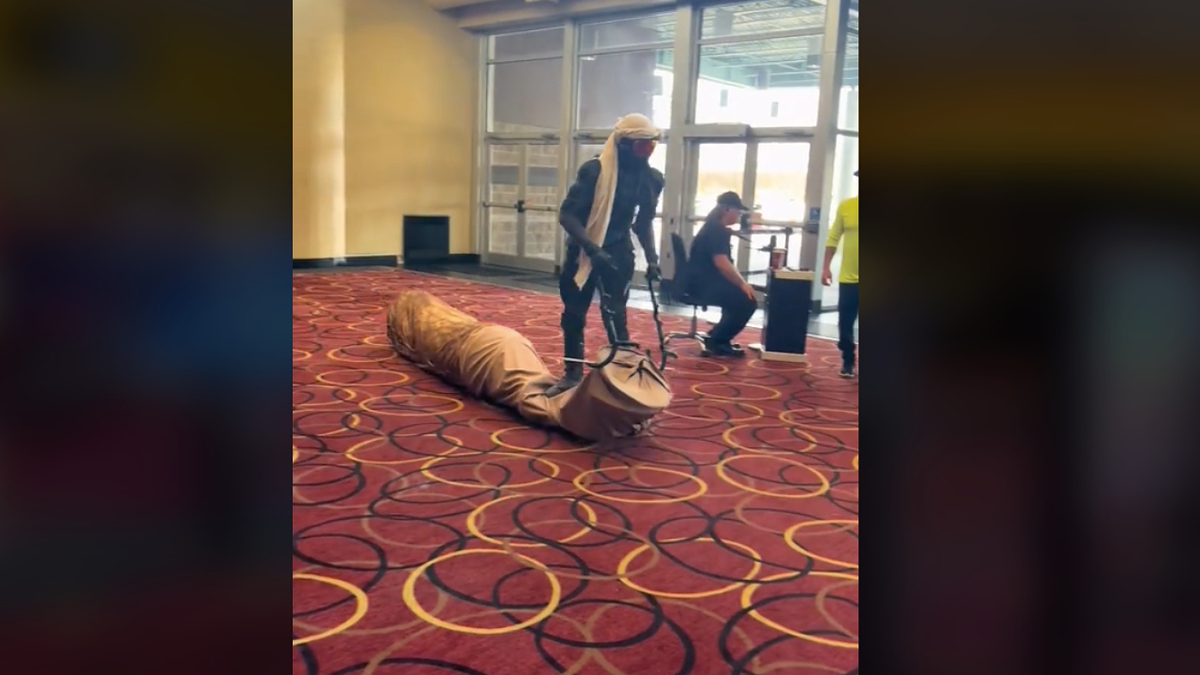 man rides worm in theater