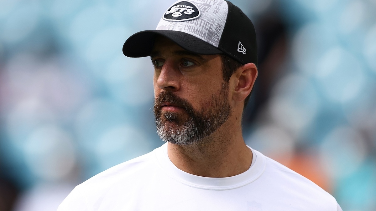 Man wearing a cap and sports team attire with logo, looking serious