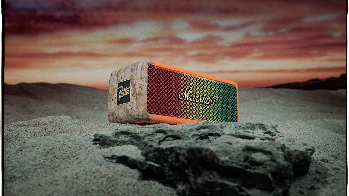 Marshall portable speaker on sand with a sunset backdrop