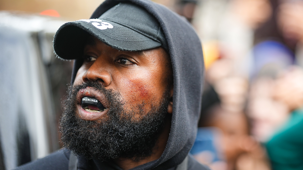 Kanye West wearing a Balenciaga mouth guard outside outside Givenchy, during Paris Fashion Week in October 2022