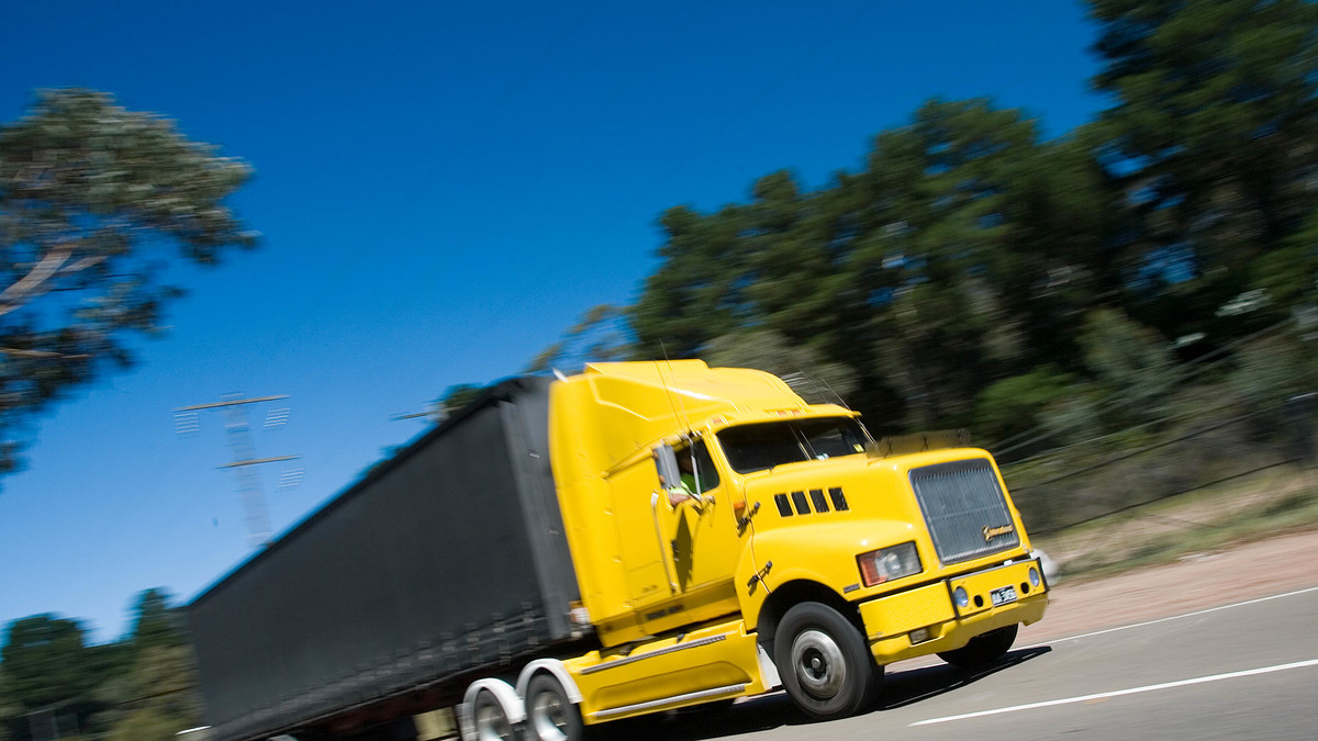 yellow truck driving on the road