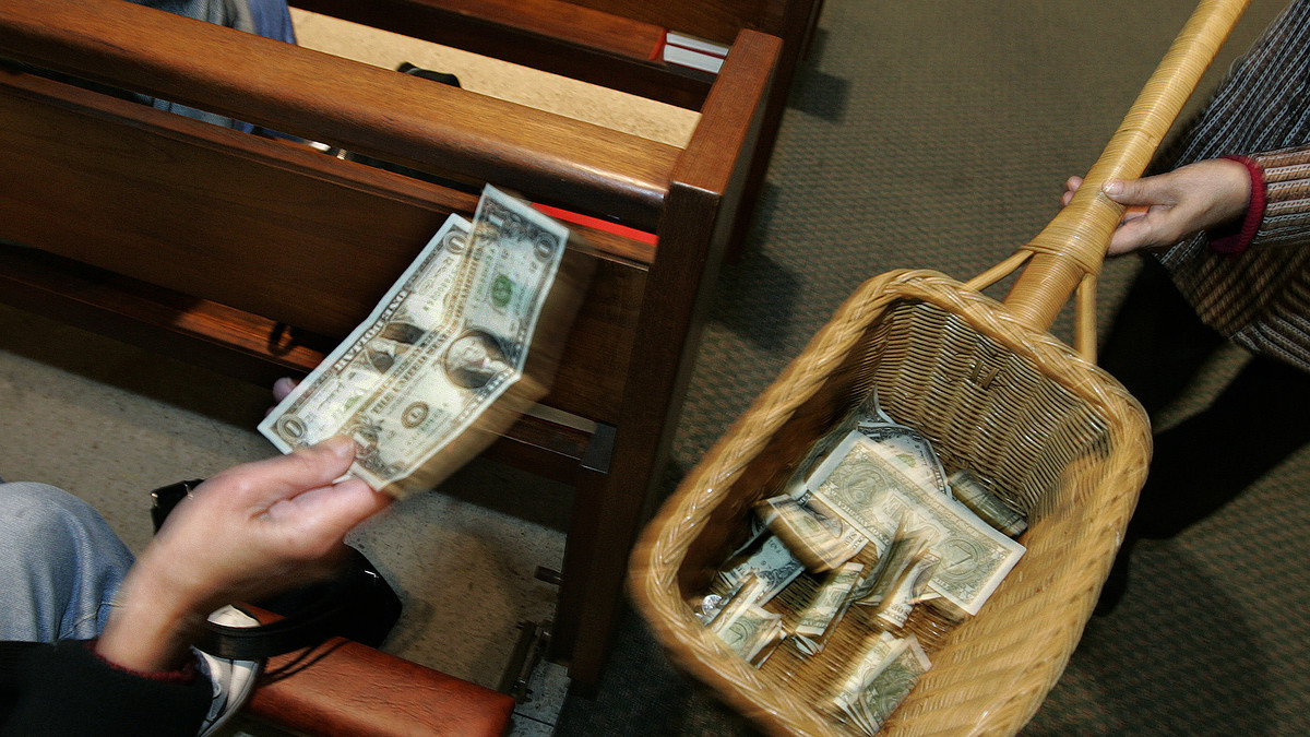 A churchgoer places money in the offering basket