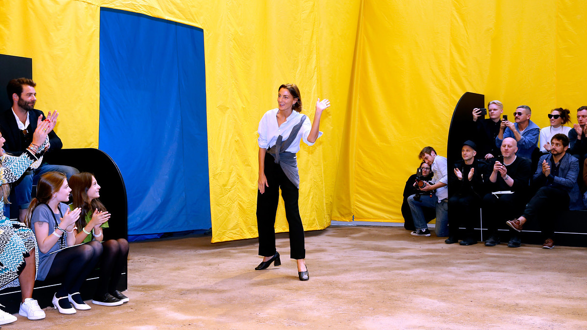 Phoebe Philo waves to the audience at a show
