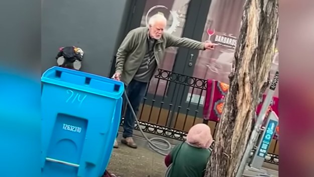 A screenshot from viral footage of an unhoused woman being hosed is pictured
