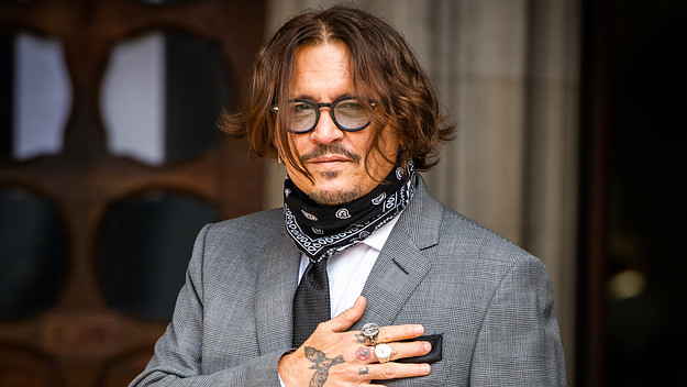 Johnny Depp acknowledges photographers outside Royal Courts of Justice.
