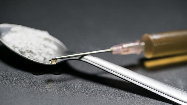 A spoonful of cocaine and a syringe of heroin
