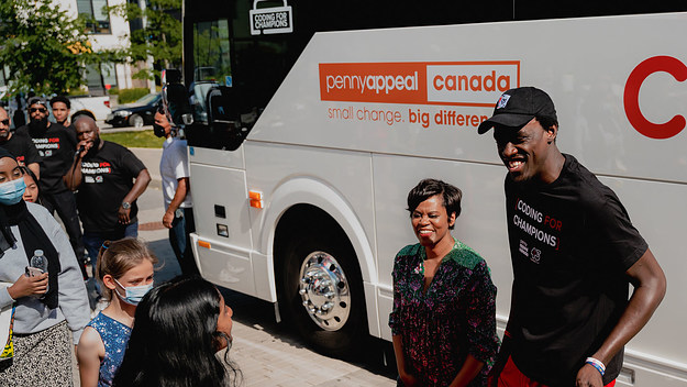 Pascal Siakam and Marci Ien handing out laptops to kids in Regent Park