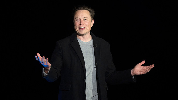 Elon Musk seen gesturing while speaking at a press conference.