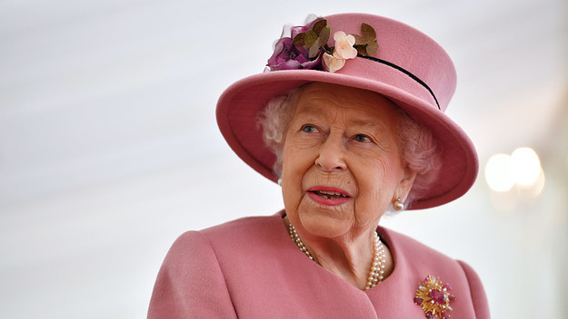 Queen Elizabeth II speaks with staff during a visit.