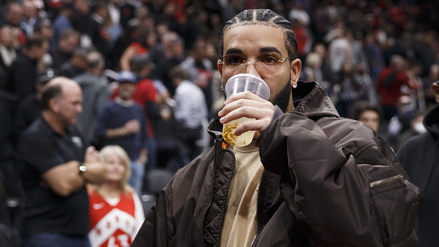 Rapper Drake drinks from a cup as he leaves the court after the first half of Game Six of the Eastern Conference First Round