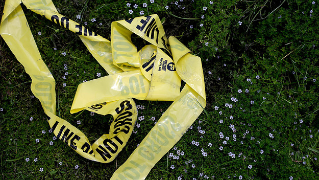 Yellow police crime scene tape rests in the grass on July 19, 2016 in Baton Rouge, Louisiana.
