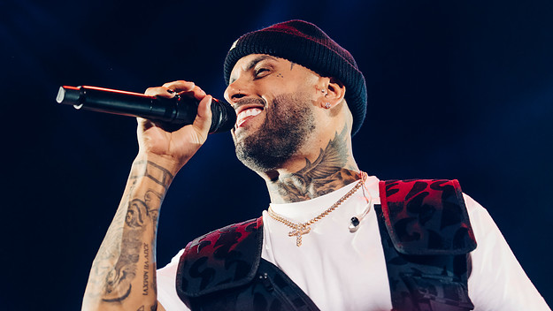 Nicky Jam performing on stage with a microphone