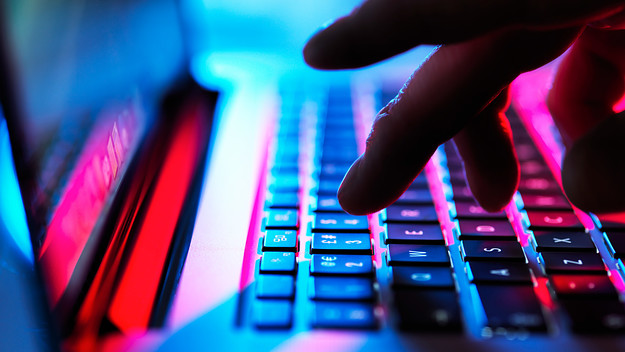 Fingers are pictured typing on a keyboard