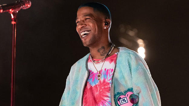 Kid Cudi is pictured smiling during a live show