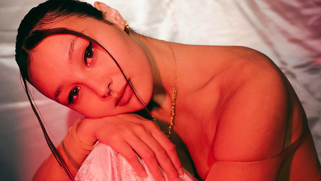 Luna Li sitting in front of a pink sheet