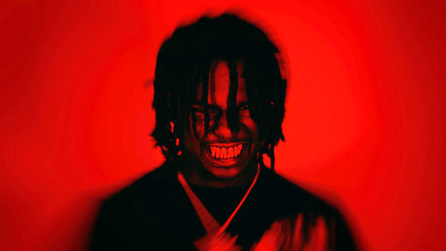 Duvy posing against red background, glaring teeth
