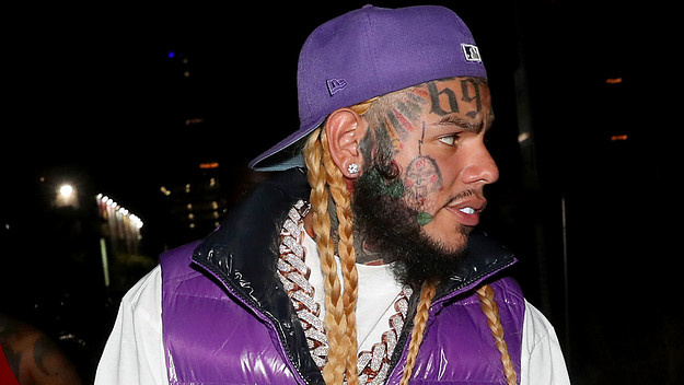 Musical artist 6ix9ine is pictured wearing a hat and vest
