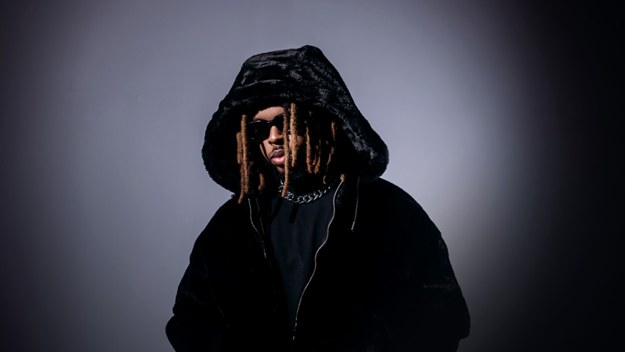 Promotional photo of FRVRFRIDAY posing in a black fur coat and black shades.