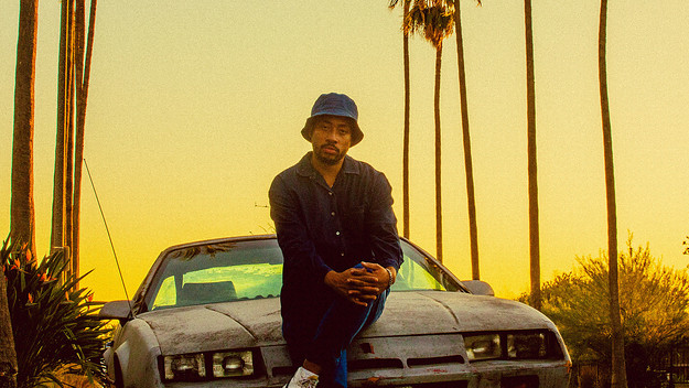 Cadence Weapon sitting on a car