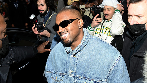 Ye is seen walking through a swarm of cameras