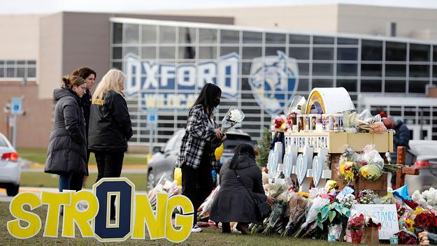 People gather at the memorial for the dead and wounded outside of Oxford High School in Oxford, Michigan