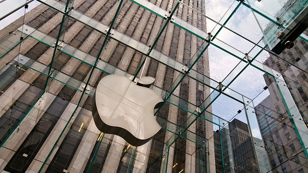 An Apple logo is pictured in a city environment