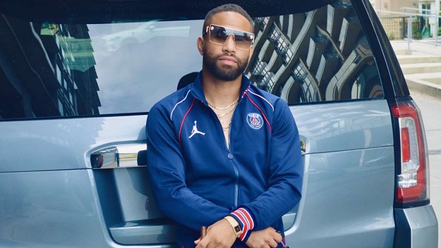 Photo of Nibbs in a Nike Air Jordan jacket in front of a car.