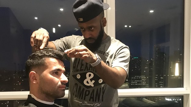 Patrice Alexander trimming a client's hair.