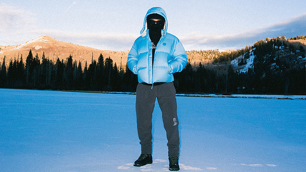 Model wearing a blue puffer jacket in the snow