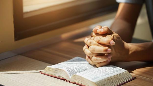 a man praying over the holy bible