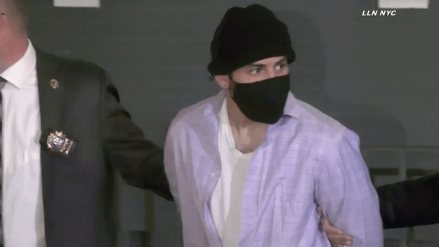 Suspect Paulie Velez walking alongside police