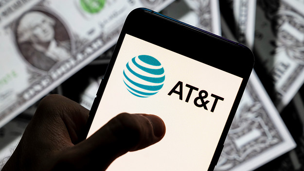 In this photo illustration, an AT&T logo seen displayed on a smartphone with USD (United States dollar) currency in the background.