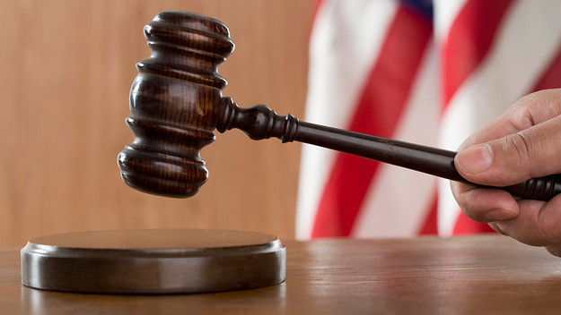 A photo of a gavel in a courtroom is shown.