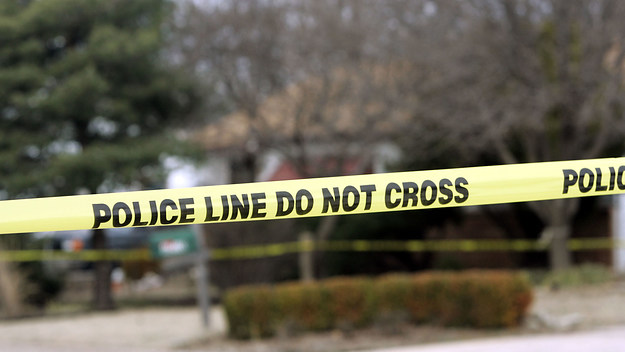 Police tape hangs across the street