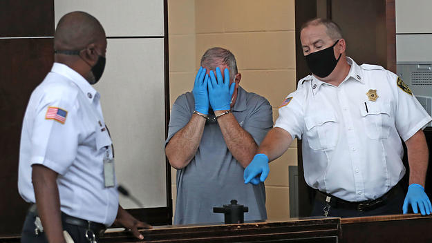Patrick Rose covers his face during his arraignment at Boston Municipal Court in August 2020.
