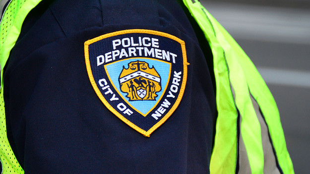 A New York City police officer stands at a busy street corner in New York.
