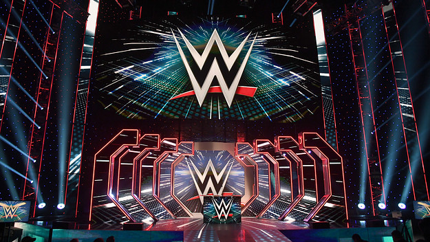 WWE logos are shown on screens before a WWE news conference.