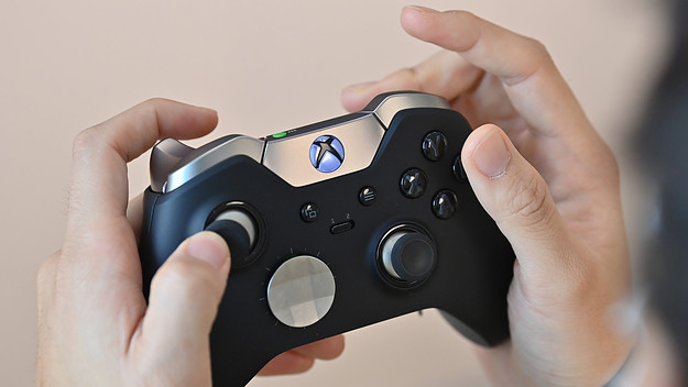 A visitor plays a game using Microsoft's Xbox controller at a flagship store of SK Telecom in Seoul