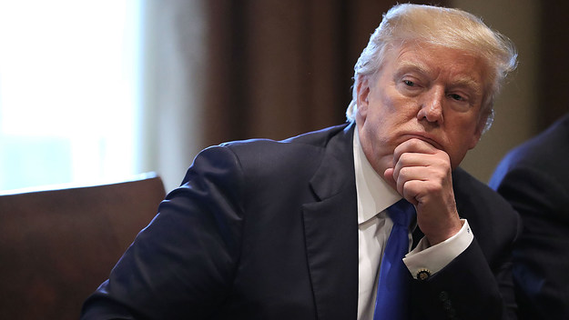 Donald Trump (R) presides over a meeting about immigration.