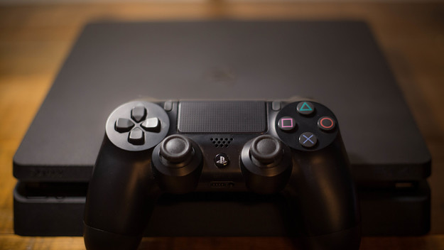 A Sony PlayStation 4 video game console with a black wireless controller
